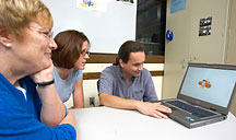 Image of researchers reviewing a laptop assessment